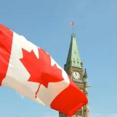The Canadian flag in front of the Peace Tower on Parliament Hill